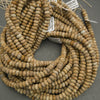 String of beige beads with visible texture on a gray background