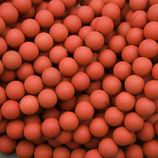 A close-up pile of matte terracotta orange-red plastic balls filling the frame.