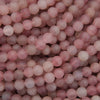 A close-up pile of round, matte pink beads with a soft, semi-translucent finish.