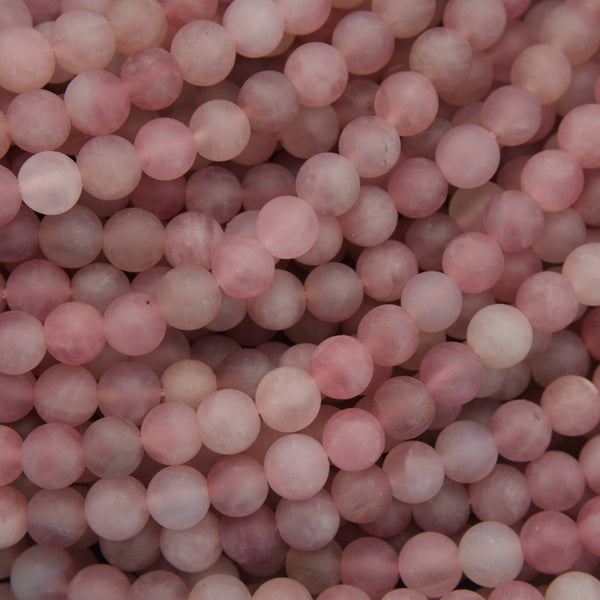 A close-up pile of round, matte pink beads with a soft, semi-translucent finish.