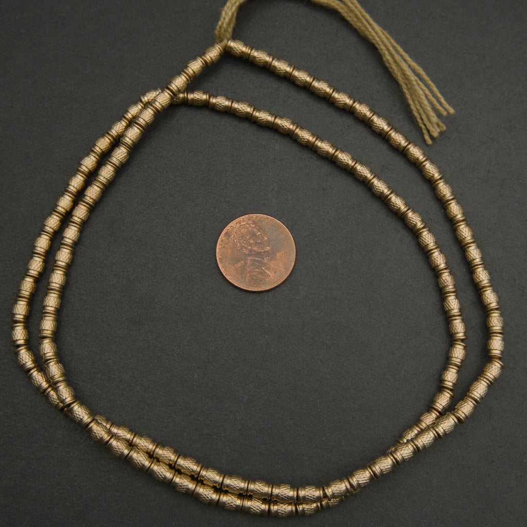 Bronze beaded necklace on a dark surface with a coin for scale