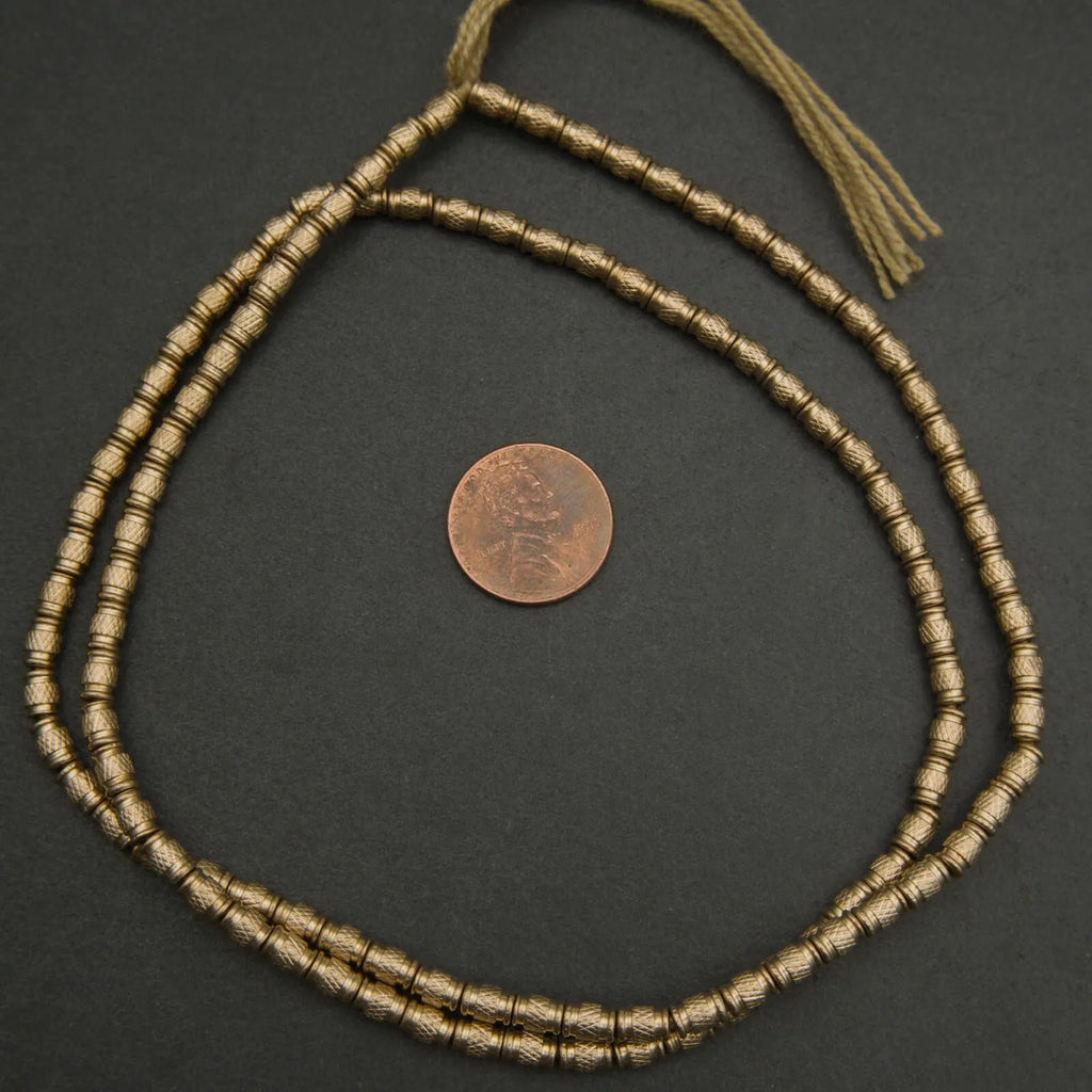 Bronze beaded necklace on a dark surface with a coin for scale