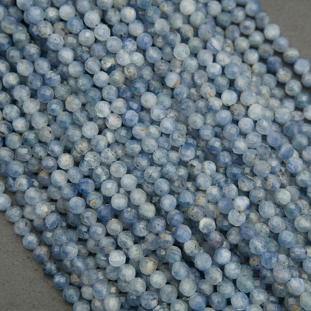 Close-up of natural blue kyanite gemstone beads in light denim tones