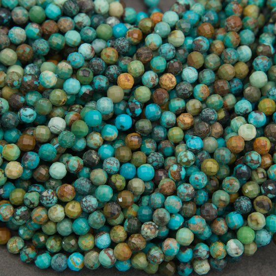 A close-up pile of faceted round beads in a mottled turquoise, teal, green, brown, and cream colorway.