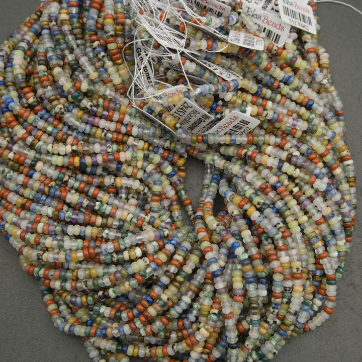 Multicolored beads on a string with 'Beads' tags attached, on a gray background