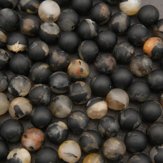 Matte calico tourmaline round beads featuring bold black, cream, tan, and rust-colored natural patterns.
