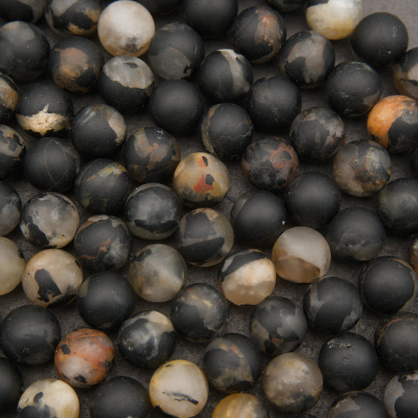 Matte calico tourmaline round beads featuring bold black, cream, tan, and rust-colored natural patterns.