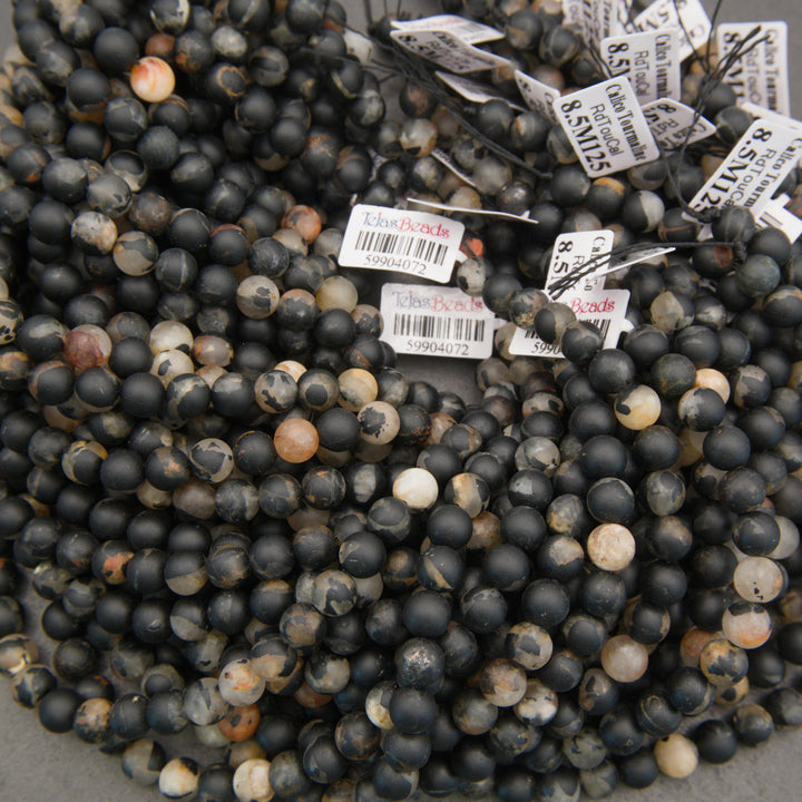 Black and cream calico tourmaline gemstone beads with irregular earthy markings for handmade bracelets and necklaces.
