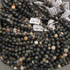 Black and cream calico tourmaline gemstone beads with irregular earthy markings for handmade bracelets and necklaces.