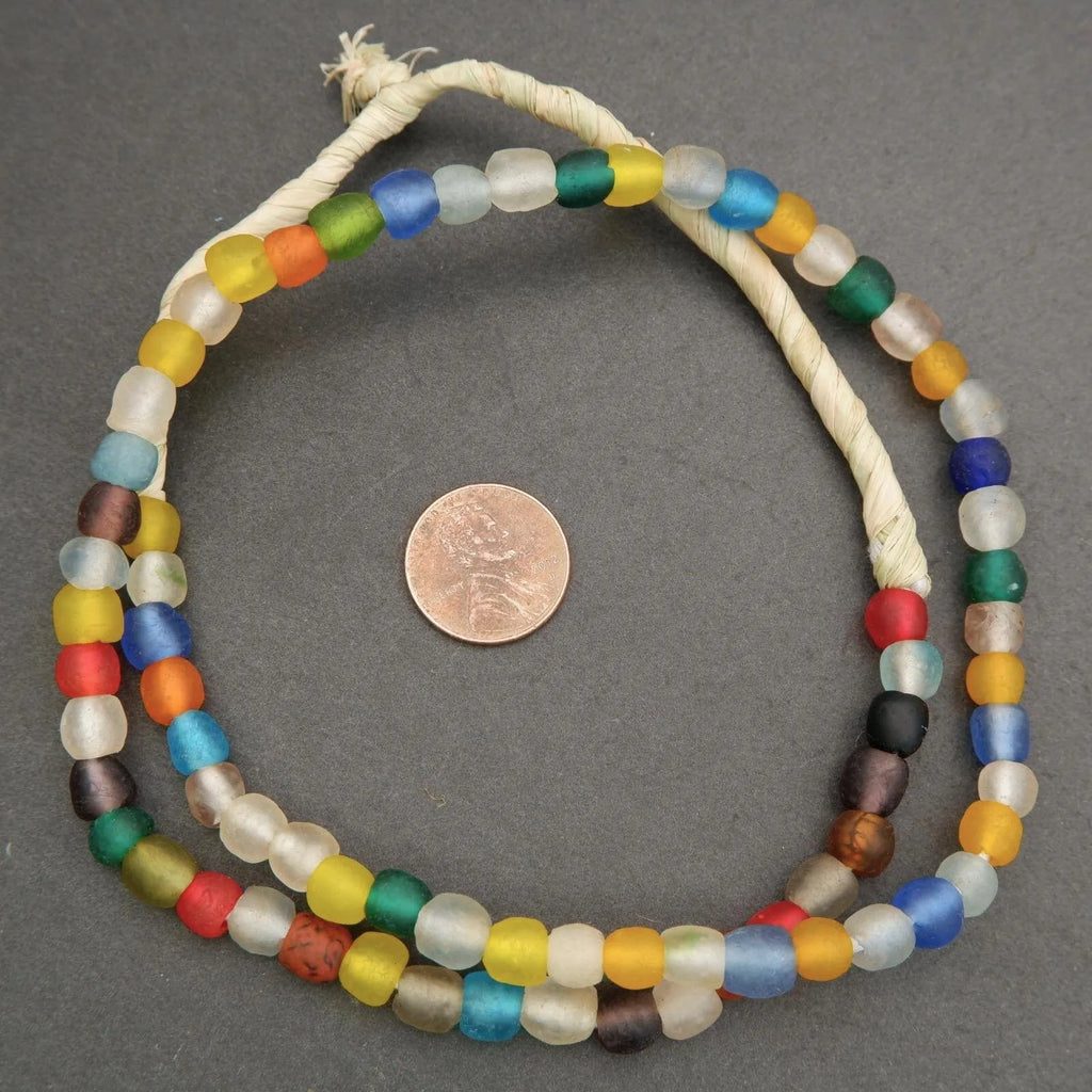 Colorful beaded necklace on a gray background with a coin for scale