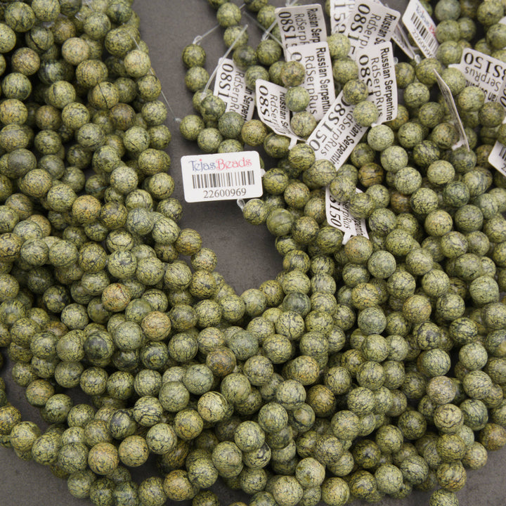 Close-up of matte Russian Serpentine beads with varied olive and yellow-green patterns