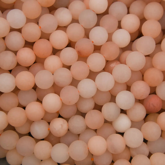 Close-up of a large number of light pink beads.