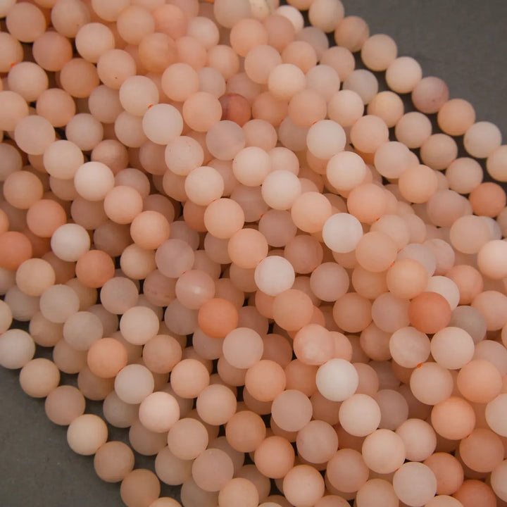 Close-up of a pile of pinkish-beige beads on a dark background