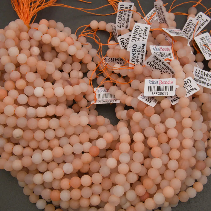 Pink beads with labels on a dark surface