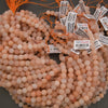 Pink beads with labels on a dark surface