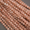 Close-up of natural peach moonstone gemstone beads with a frosted matte finish and subtle pearly shimmer.