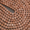 Peach moonstone round gemstone beads with subtle natural shimmer and warm pink tones for handmade jewelry.