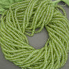 Premium peridot gemstone beads in vibrant green tones, faceted rondelle strand
