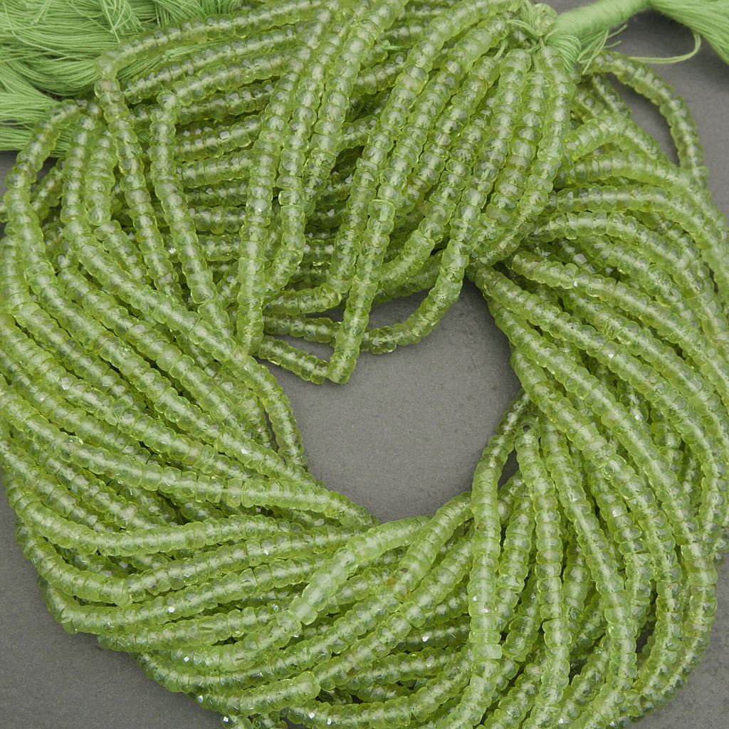 Premium peridot gemstone beads in vibrant green tones, faceted rondelle strand