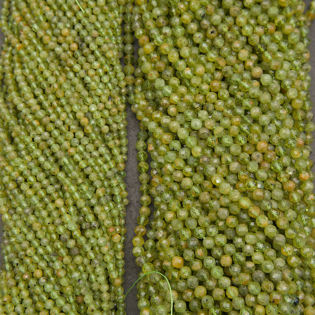 Close-up of multiple strands of faceted green beads, likely seed beads for jewelry making, arranged vertically.