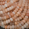 Polished Peach Aventurine rondelle gemstone beads on strands.