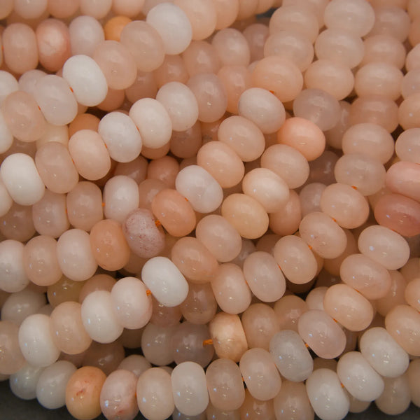 Polished Peach Aventurine rondelle gemstone beads on strands.