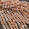 Peach Aventurine rondelle beads featuring warm pastel tones and a glossy finish.