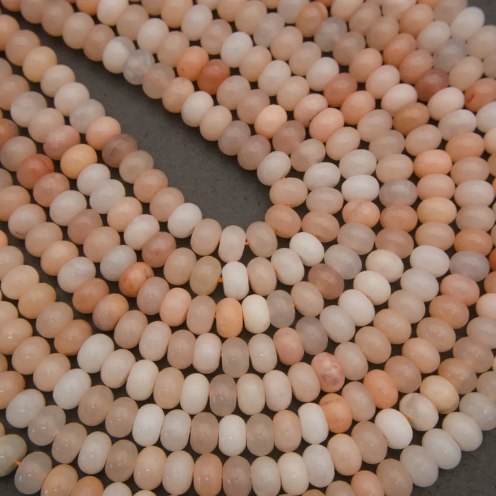 Polished Peach Aventurine bead strands in shades of peach, ivory, and blush.