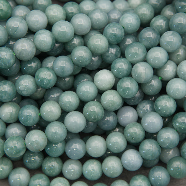 Natural Guatemalan jade round beads featuring soft mint green, seafoam, and teal tones with a glossy polished finish.