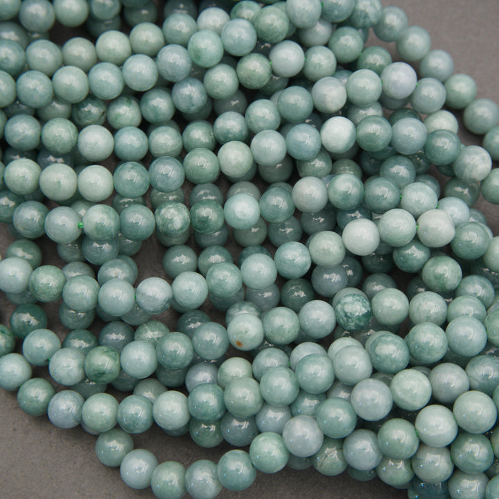 Multiple strands of Guatemalan jade round beads displaying soothing shades of pale green, blue-green, and soft teal.