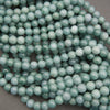 Multiple strands of Guatemalan jade round beads displaying soothing shades of pale green, blue-green, and soft teal.