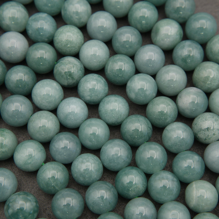 Strands of natural Guatemalan jade beads featuring soft pastel green tones and delicate mineral variations.