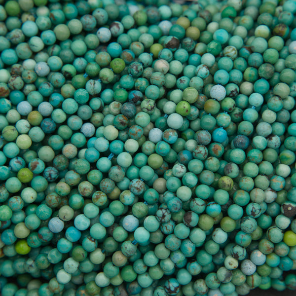 Close-up of turquoise gemstone beads featuring soft blue-green hues and natural brown veining.