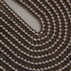 A close-up of a coiled strand of small, glossy, dark brown translucent beads on a neutral gray background.