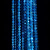 Blue apatite beads spinning in a black background.