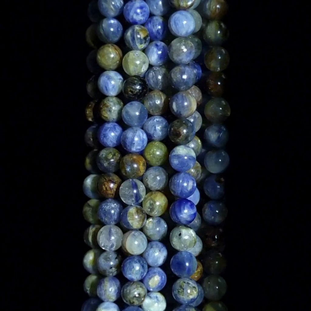 Sunset Blue Kyanite Beads Spinning with a black background.