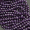 Close-up of purple amethyst beads on a gray background