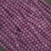 Close-up of purple round beads on a dark background