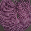 Purple beads on a string with a neutral background