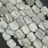 Close-up of light gray beads on a dark background