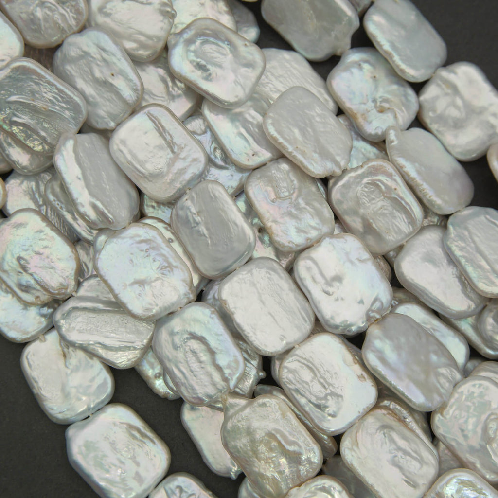 Close-up of light gray beads on a dark background