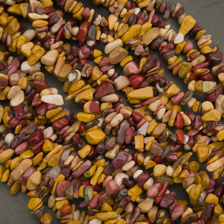 Close-up of multicolored stones arranged in a circular pattern on a dark surface