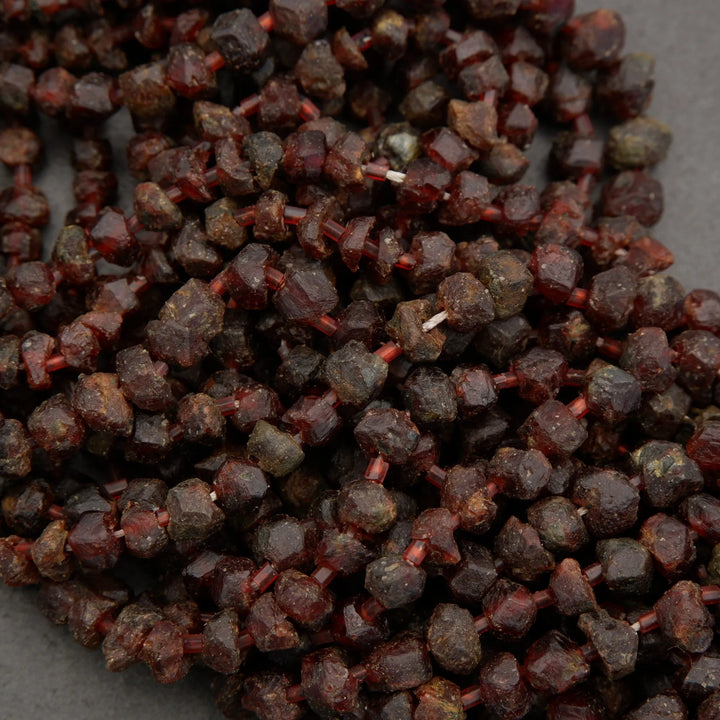 Close-up of dark red garnet gemstones on a gray background