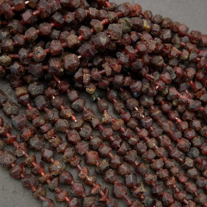 Close-up of dark red gemstone beads on a gray background
