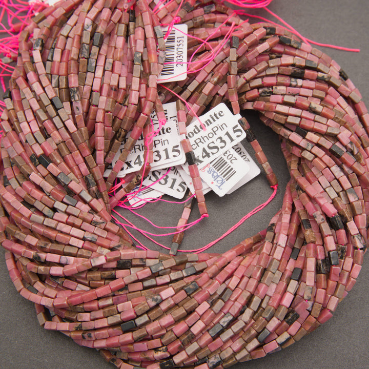 Close-up of pink rhodonite beads displaying delicate gray and black mineral markings.