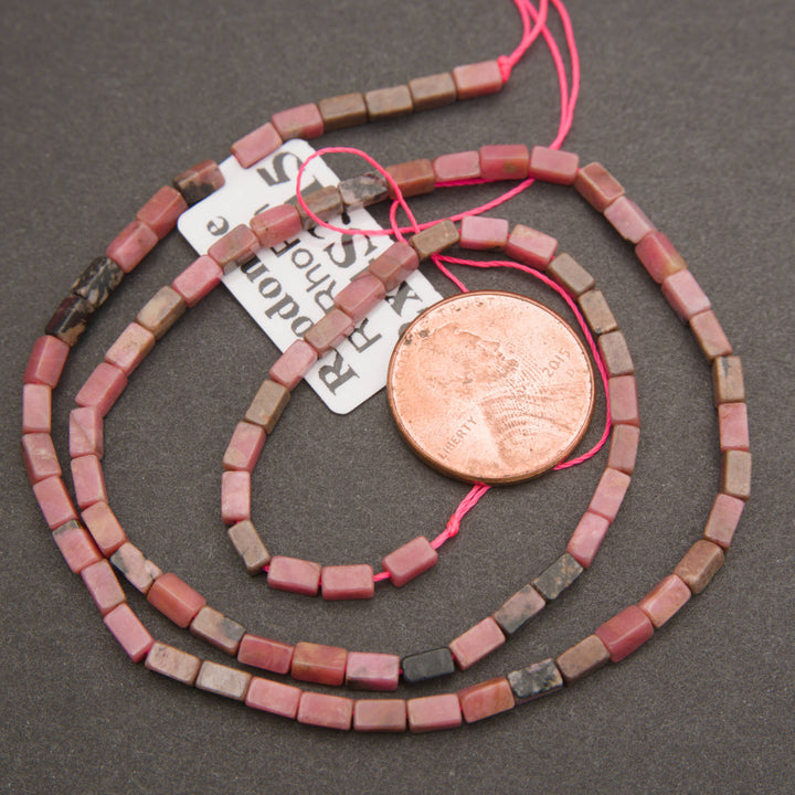 Rhodonite gemstone beads featuring smooth rectangular shapes and natural pink and black coloration.