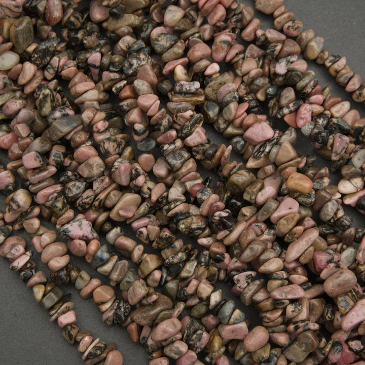 Close-up of a string of pink and brown pebble beads on a dark background