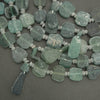 Green stone beads on a dark gray background