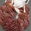 Strand of red beads with white string on a gray background