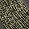 Close-up of a string of small, round beads with black speckles on a dark background
